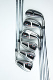 A set of six TaylorMade M6 golf iron clubs arranged diagonally on a clean white background, showing their polished metal heads and chrome shafts.